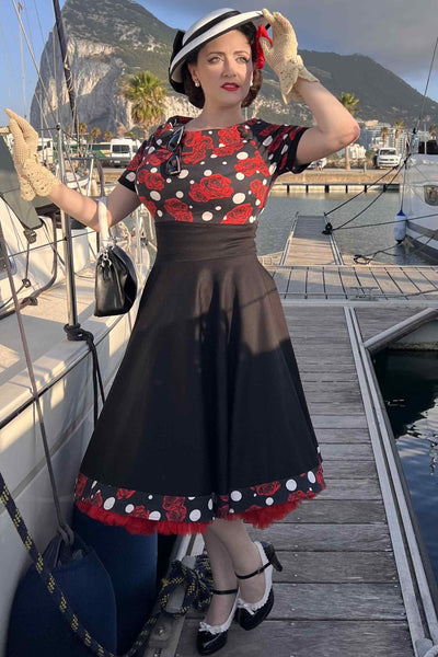 A woman wearing Rockabilly Rose Polka Dot Swing Dress