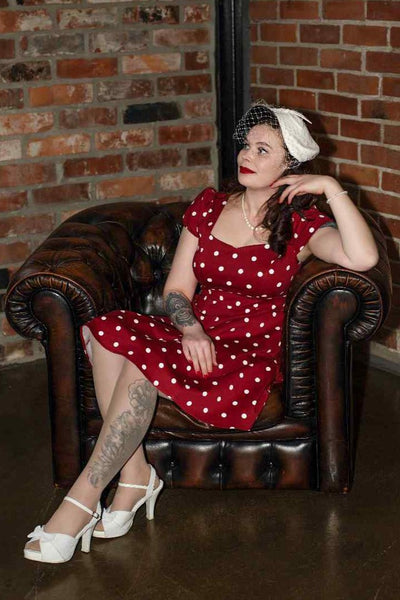 A model wearing a Fifties Style Polka Dot Dress In Burgundy-White