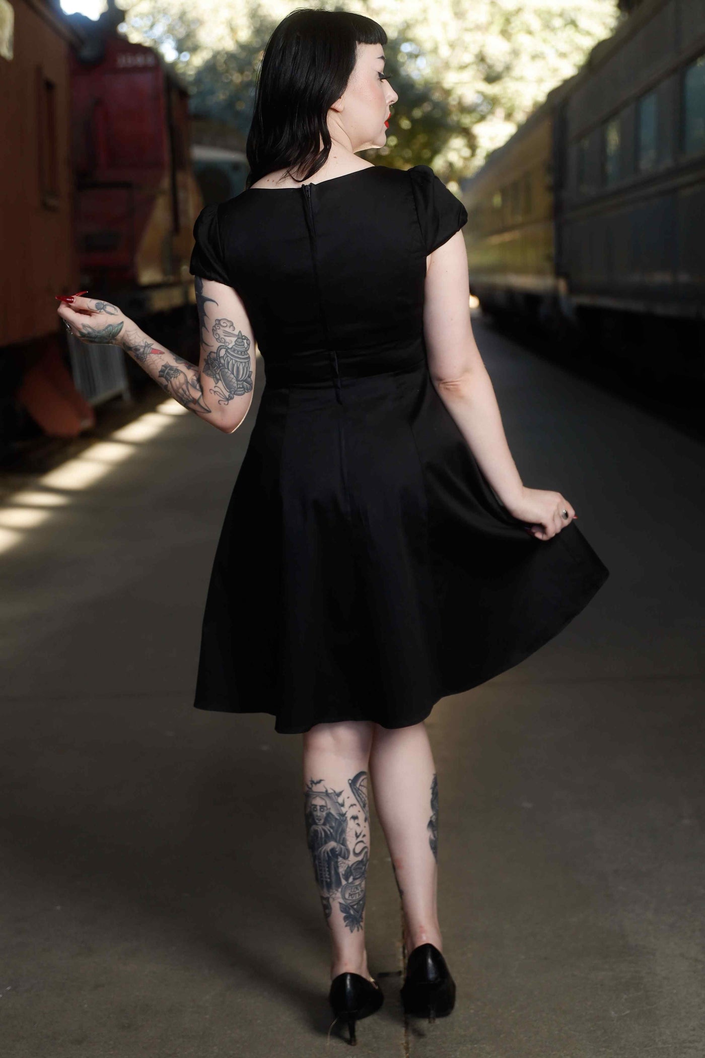 Back view of model wearing Flirty Fifties Style Dress in Plain Black