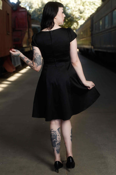 Back view of model wearing Flirty Fifties Style Dress in Plain Black