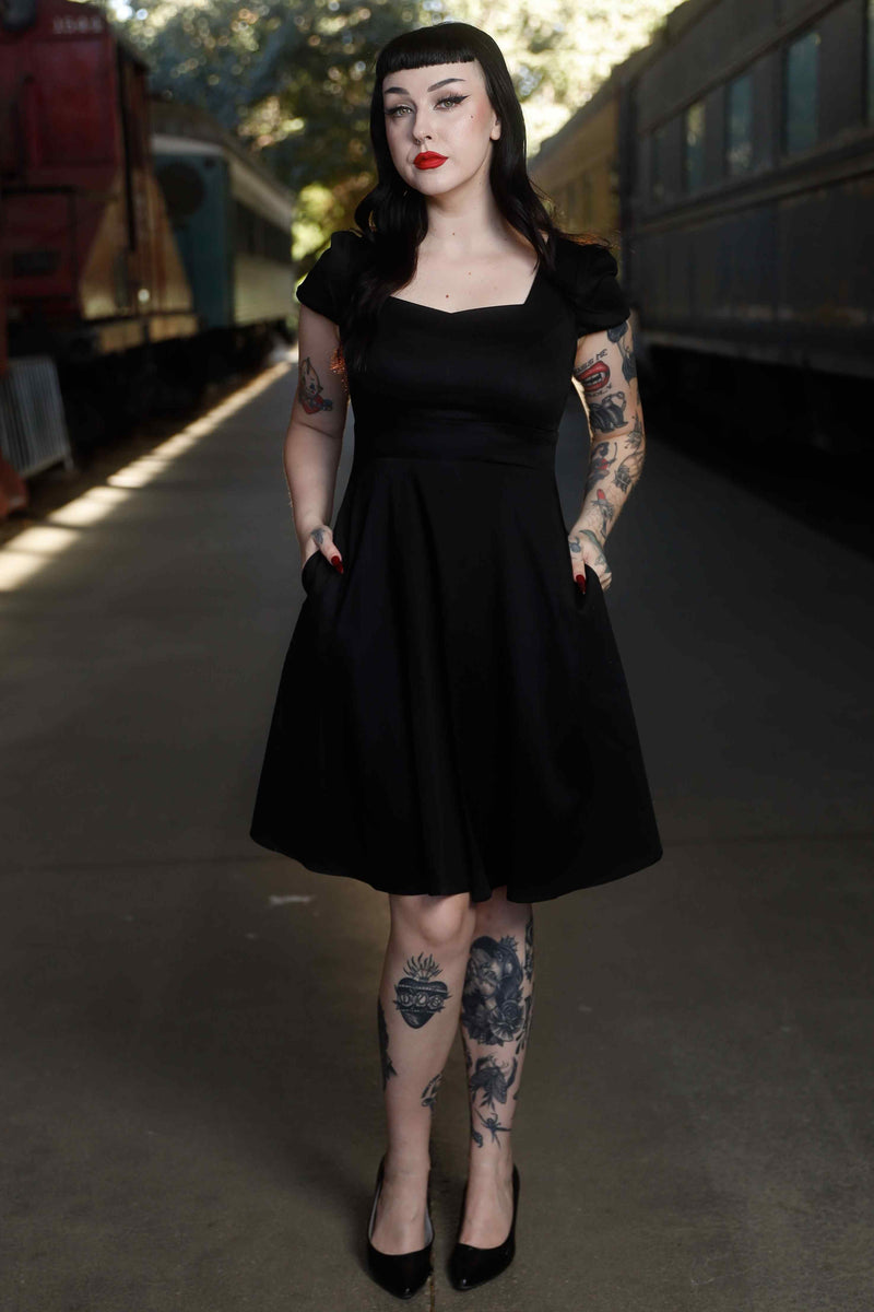 Front view of model wearing Flirty Fifties Style Dress in Plain Black