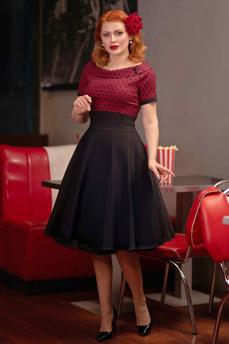 A model wearing a Full Circle Swing Dress in Burgundy Polka-Black