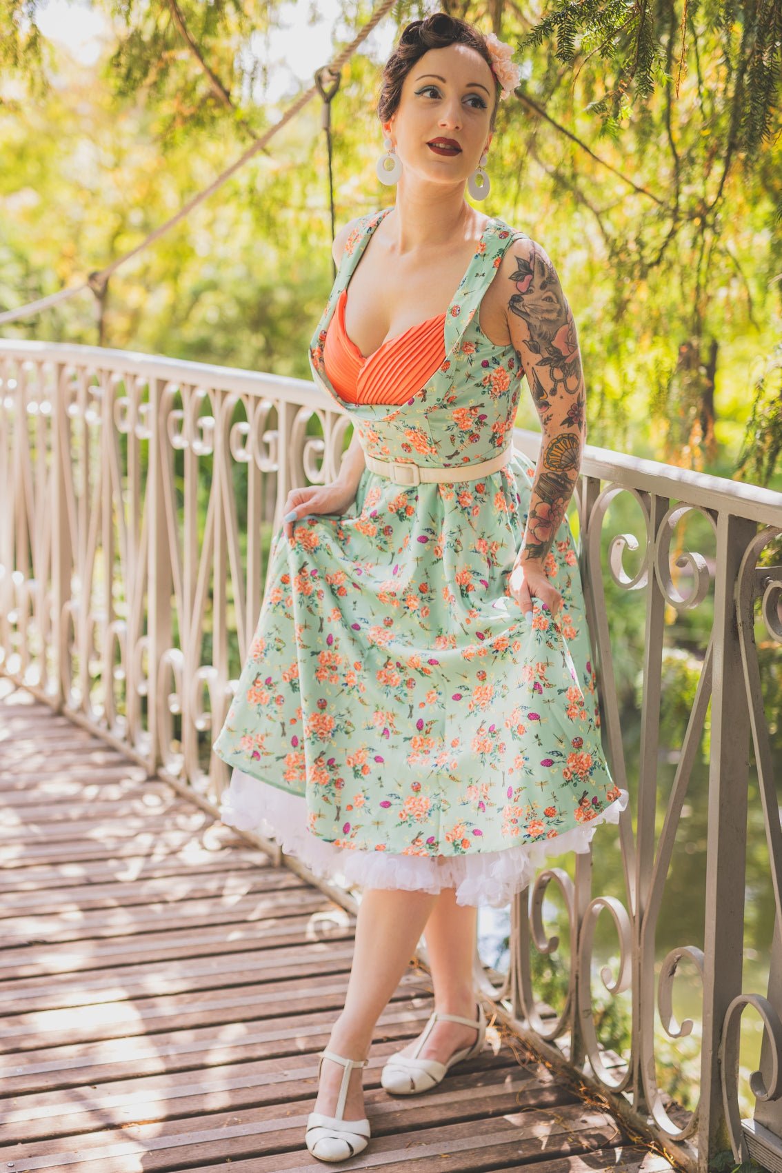 A lady wearing a Green Floral Dragonfly Pleated Bust Dress
