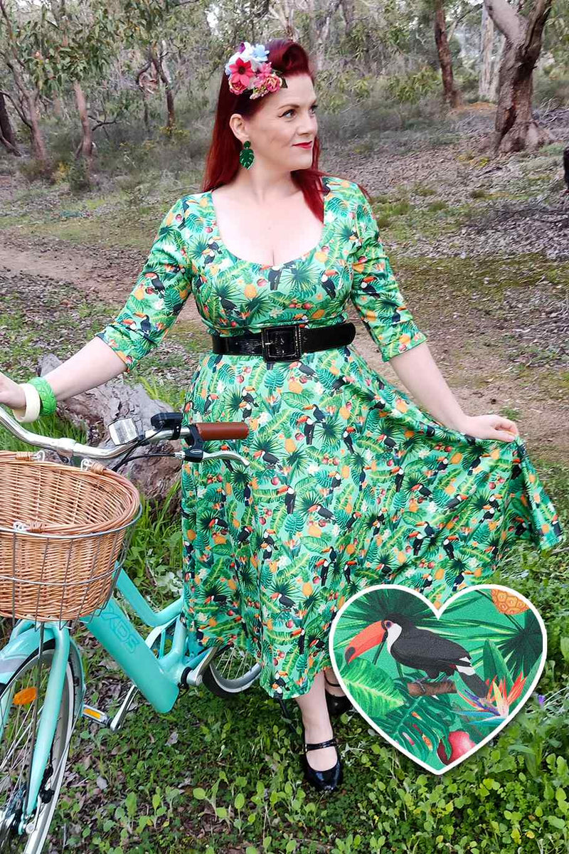 Customer wears our Green Tropical Toucan Dress with a bike, in a forest