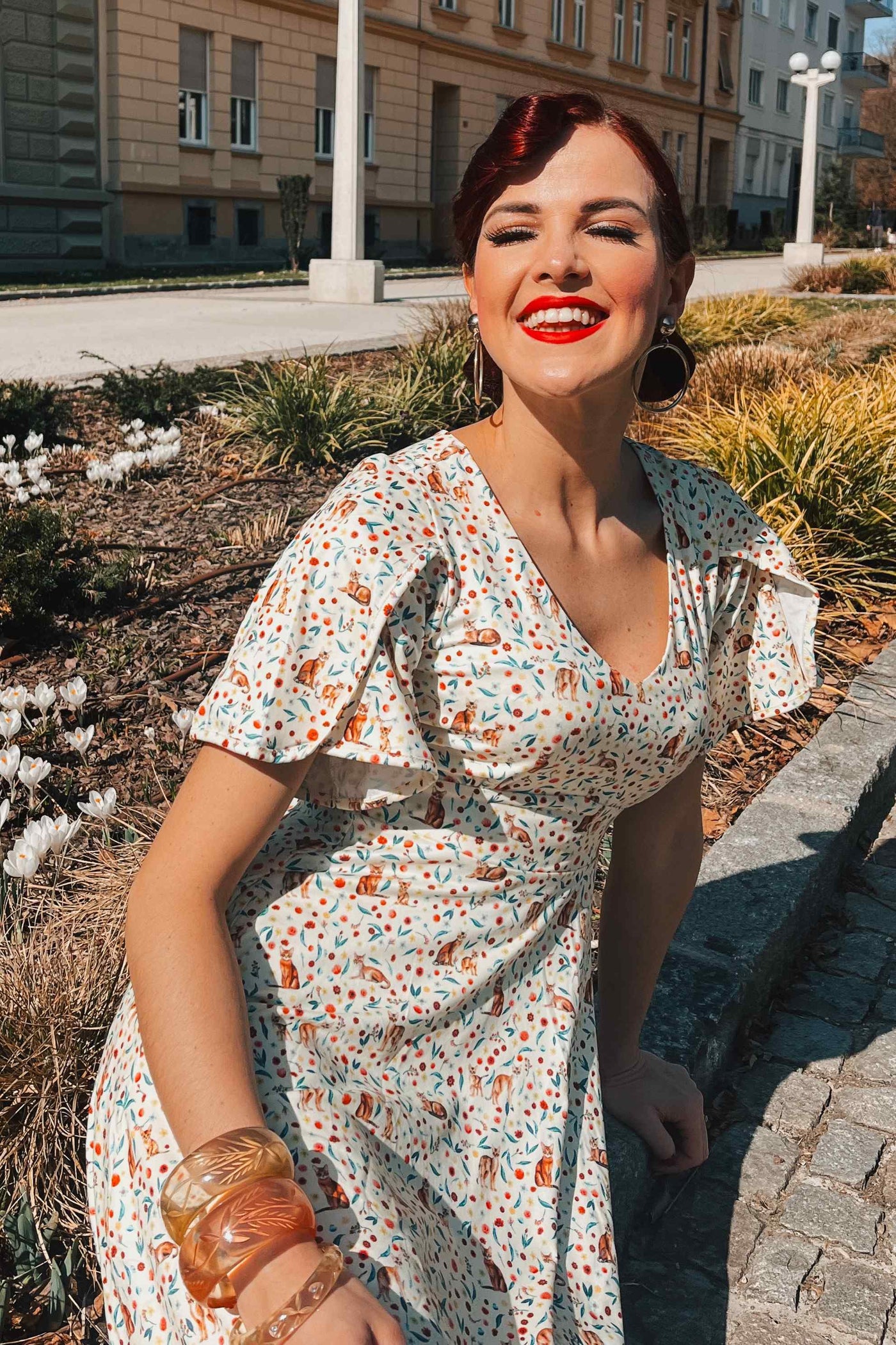 A model wearing Ivory Cream Sleeved Tea Dress in Cat Floral Print