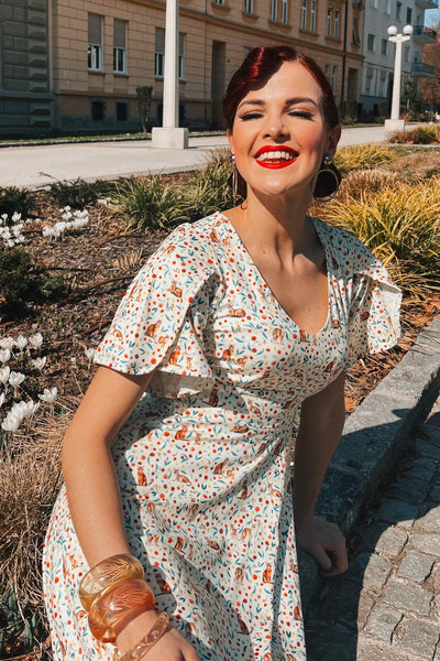 A model wearing Ivory Cream Sleeved Tea Dress in Cat Floral Print