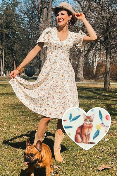 A lady wearing an Ivory Cream Sleeved Tea Dress in Cat Floral Print