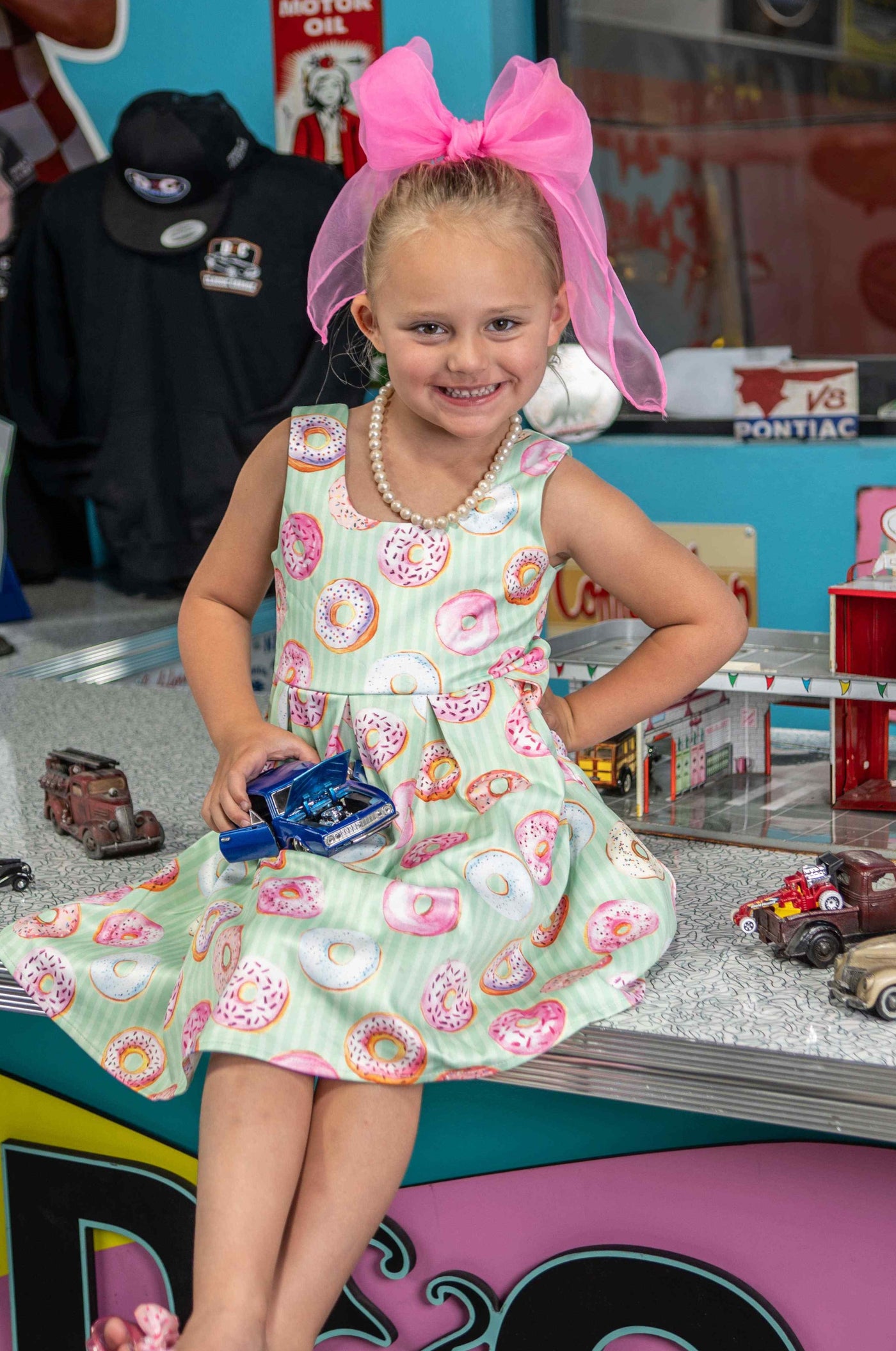 A cute child wearing a Kids Donut Green Swing Dress