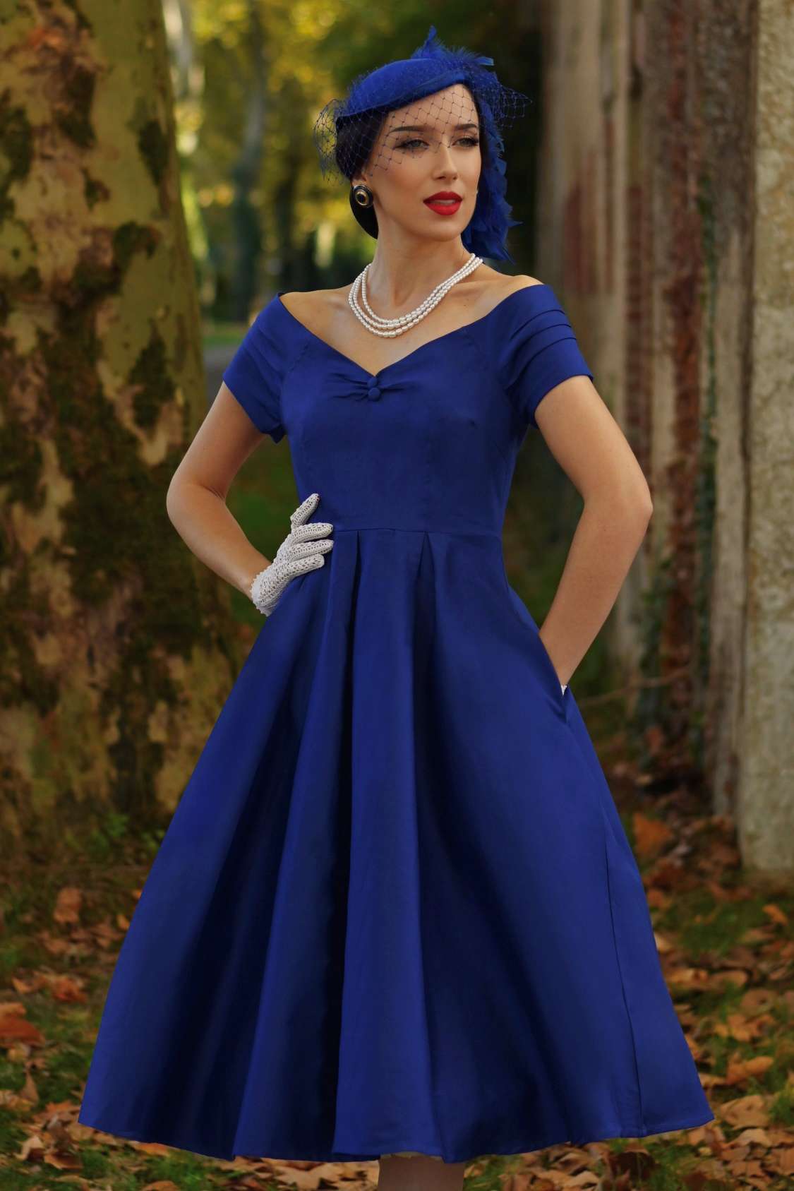 An elegant model wearing a Lily Dark Blue Off Shoulder Dress