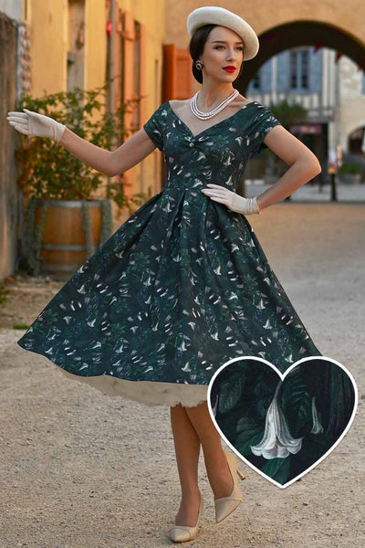 A model wearing a Lily Dark Green Off Shoulder Dress In Magpie Print