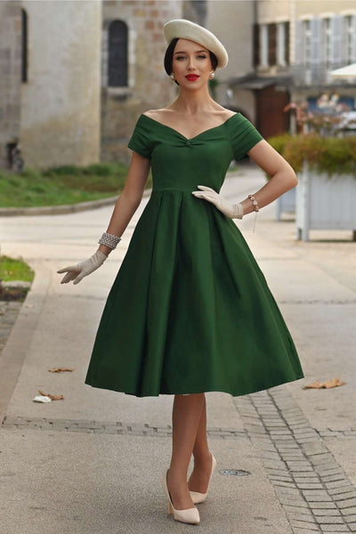 A woman wearing a Lily Dark Green Off Shoulder Dress