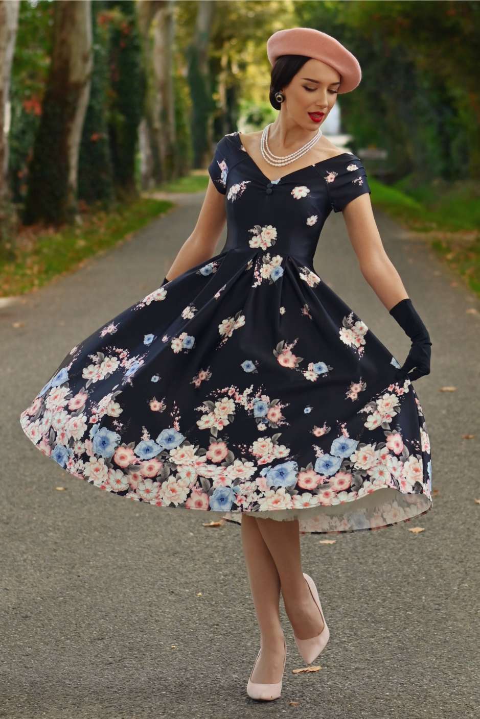 A elegant model wearing a Lily Navy Blue Falling Rose Off Shoulder Dress