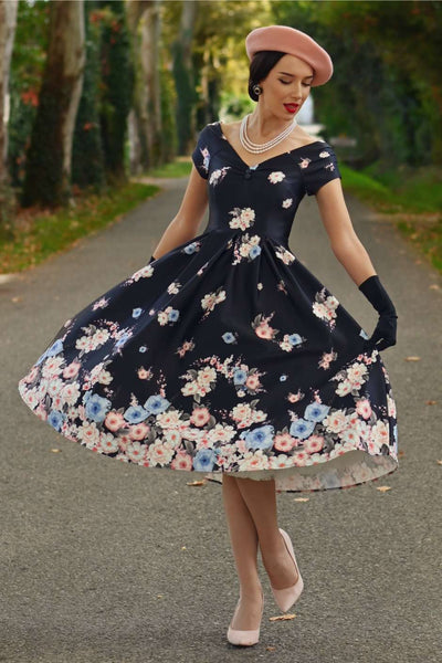 A elegant model wearing a Lily Navy Blue Falling Rose Off Shoulder Dress