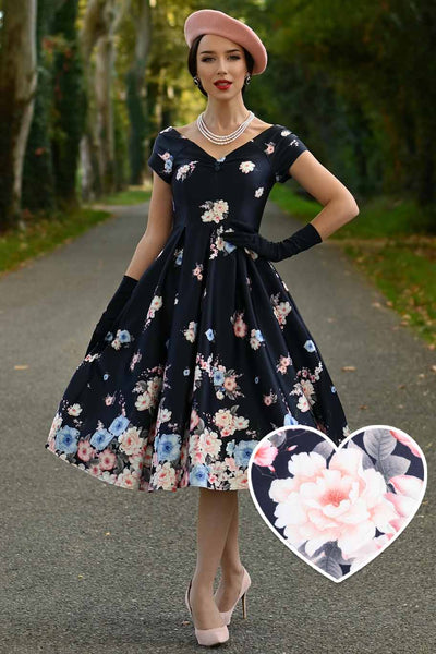 A woman wearing a Lily Navy Blue Falling Rose Off Shoulder Dress