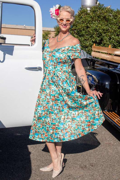 A model wearing a Lily Pinup Postcard Off Shoulder Dress