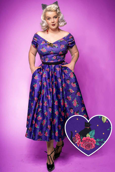 A model wearing a Lily Vintage Cat & Rose Off Shoulder Dress In Purple