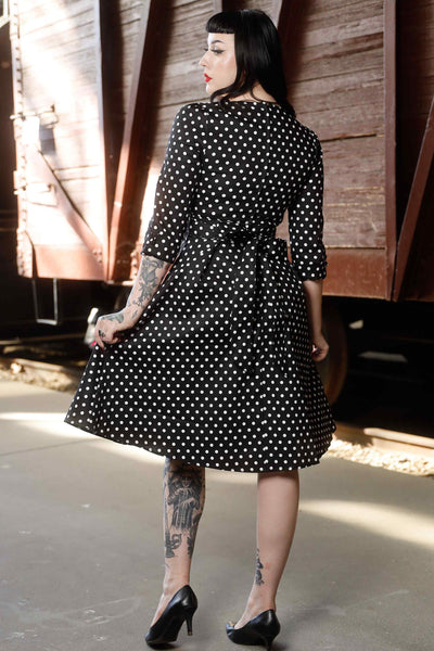 Back view of model wearing Long Sleeve 50s Style Swing Dress in Black Polka