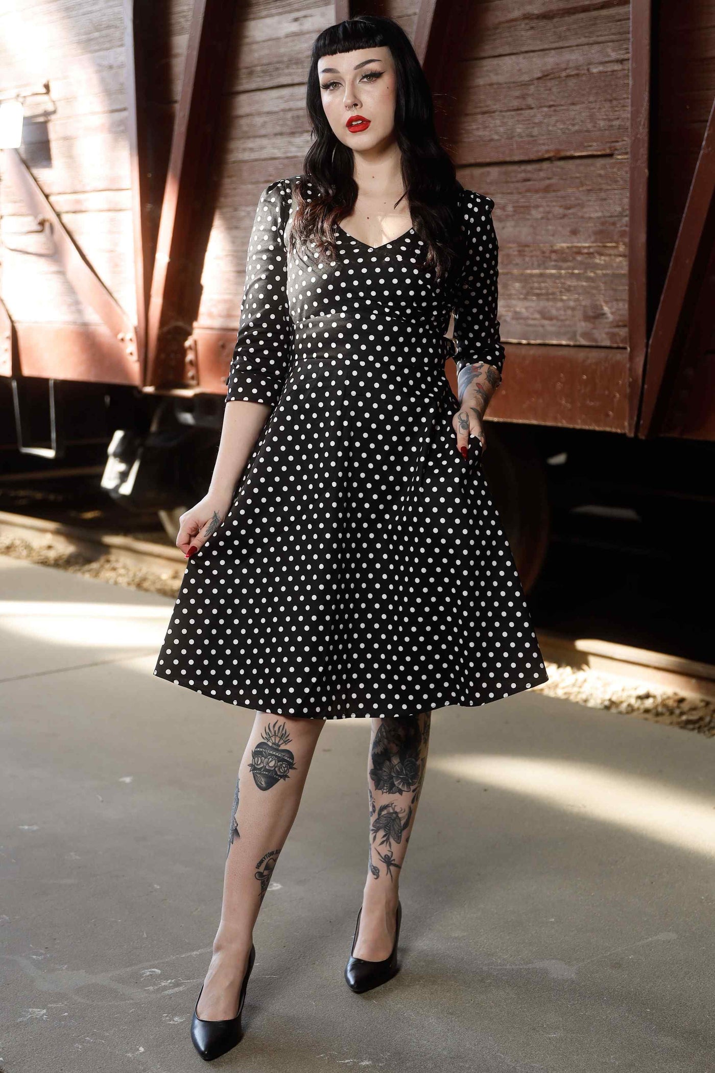 A model wearing Long Sleeve 50s Style Swing Dress in Black Polka