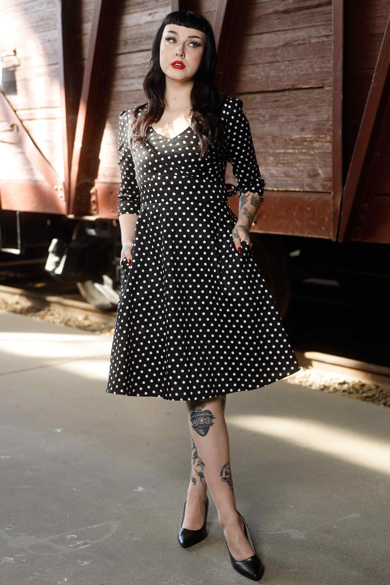 Front view of model wearing Long Sleeve 50s Style Swing Dress in Black Polka