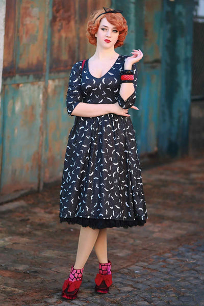 A lady wearing a Long Sleeved Black Bat Dress