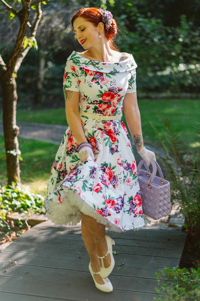 Woman wearing our Darlene Retro Floral Swing Dress in White, with a white petticoat