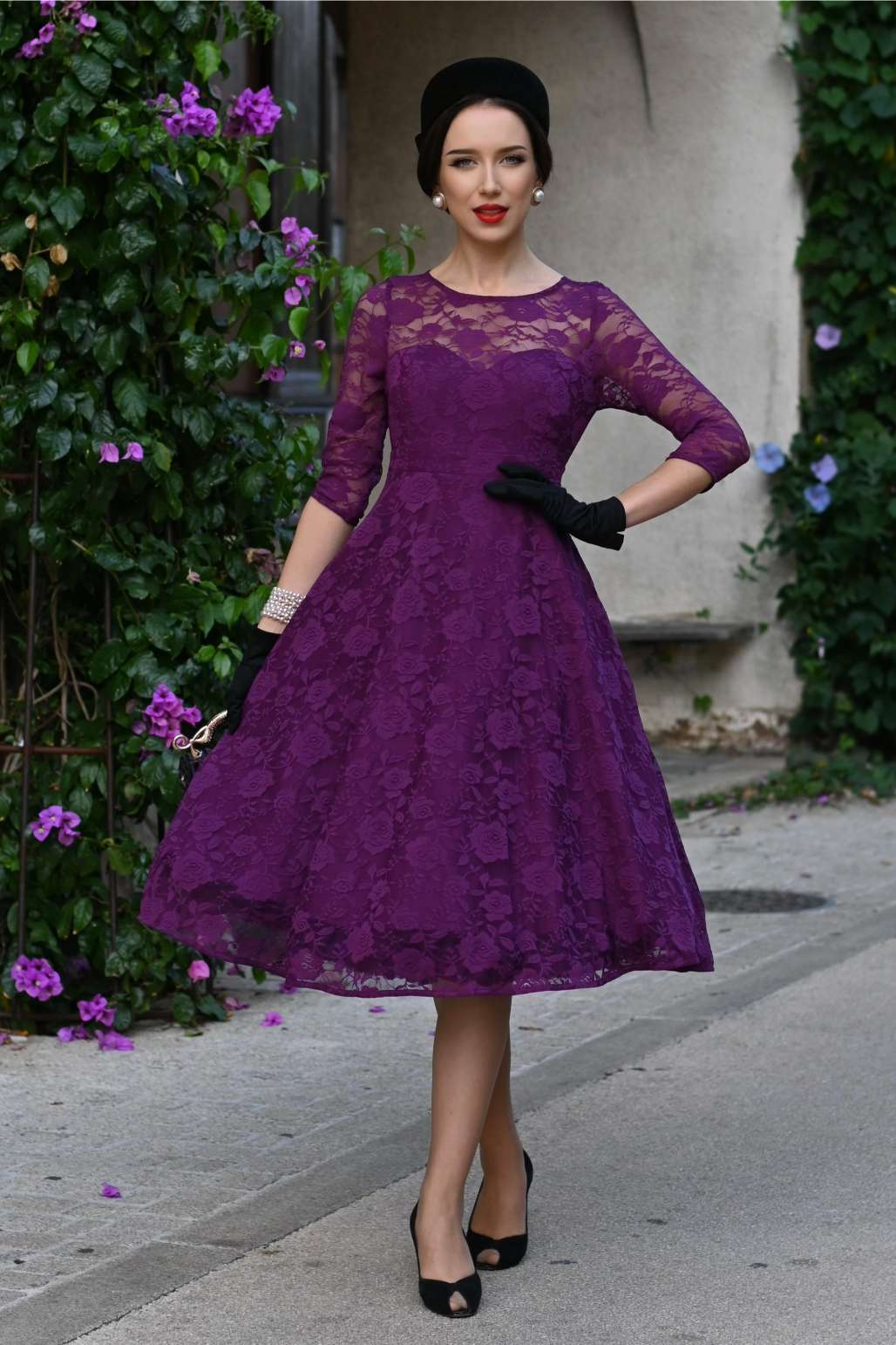 A model wearing a Madeline Long Sleeved Purple Lace Dress