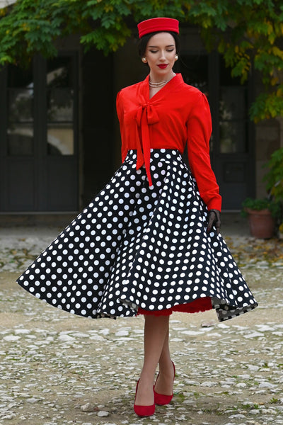 A graceful model wearing a Maisie Black Polka Dot Full Circle Midi Skirt