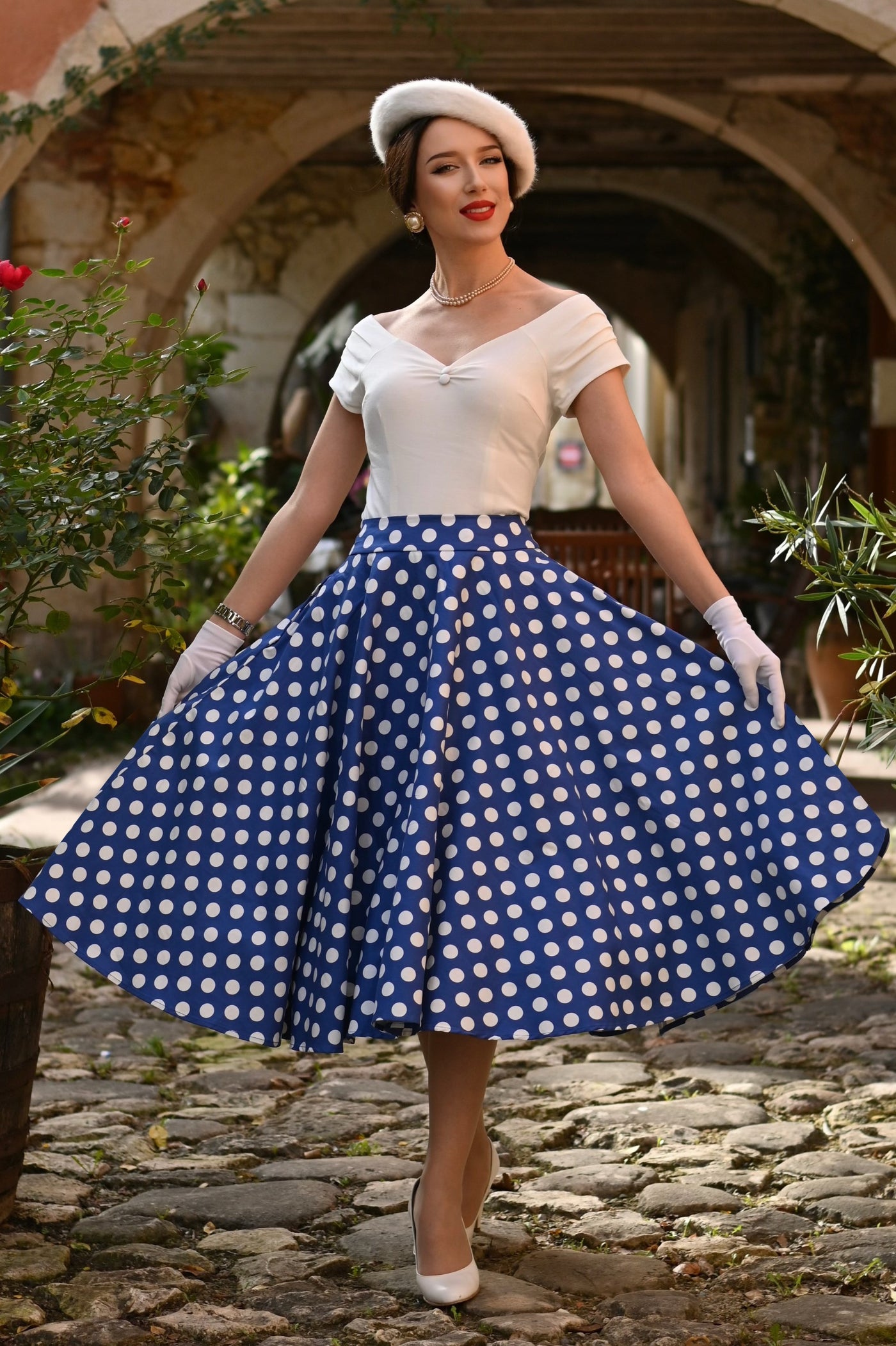 A model wearing a Maisie Navy Polka Dot Full Circle Midi Skirt
