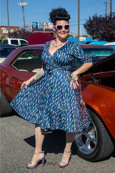 A lady wearing a Matilda Navy Blue Seahorse Wrap Dress