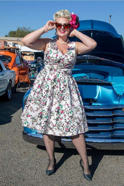 A lady wearing a May Crossover Bust Circle Dress In White Bird Print