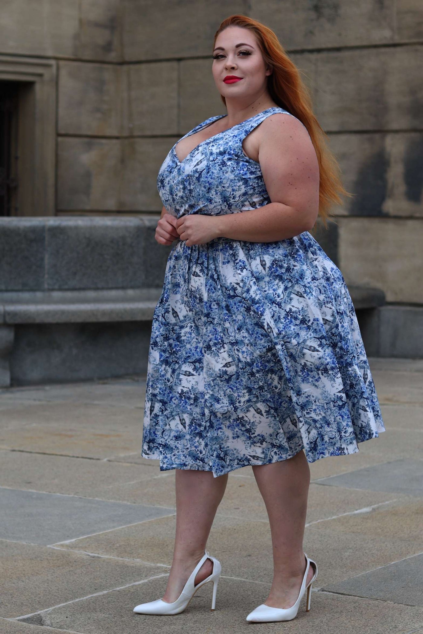 A woman wearing a May White Crossover Bust Dress In Big Ben Print