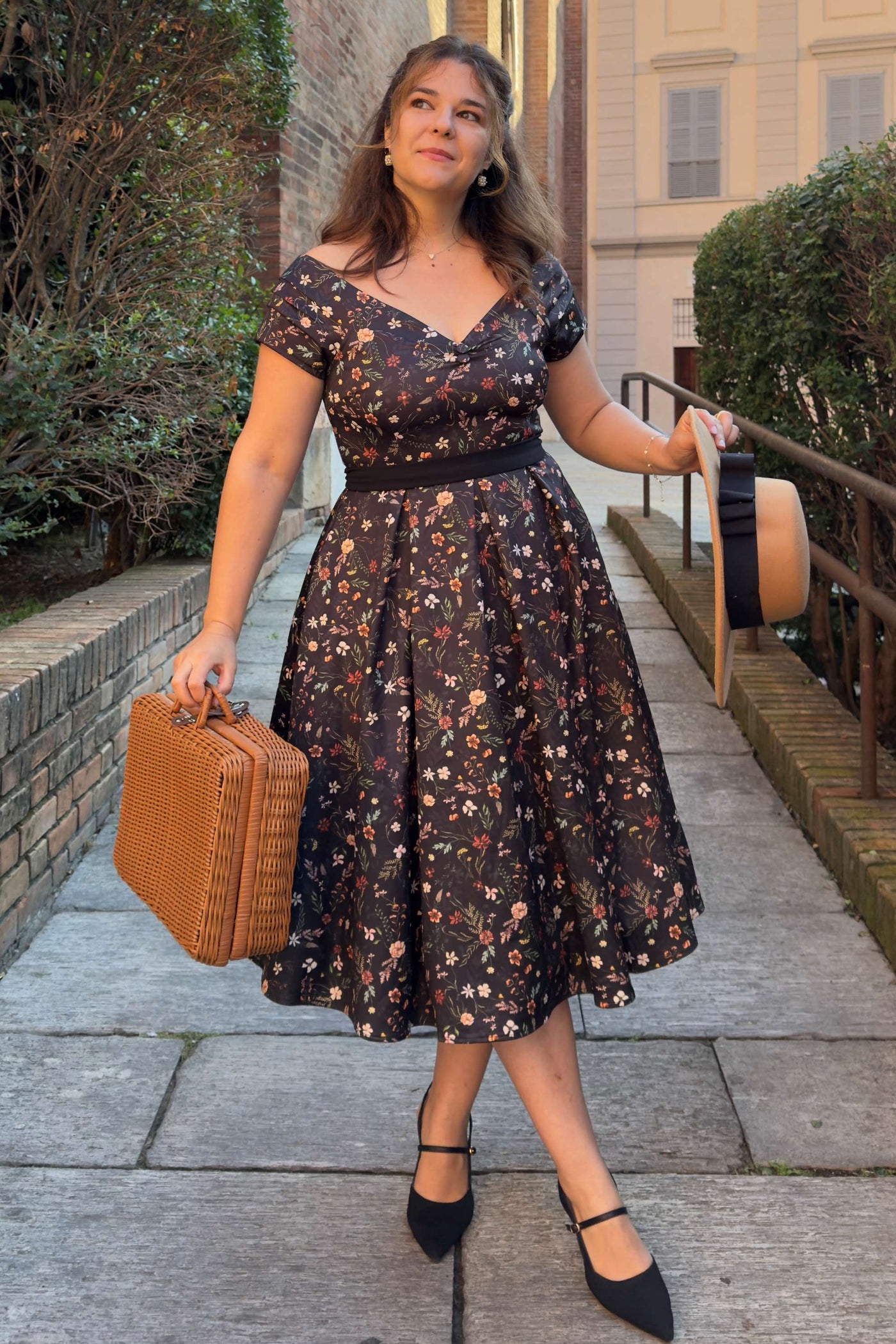 A lady wearing a Meadow Floral Black Off Shoulder Dress