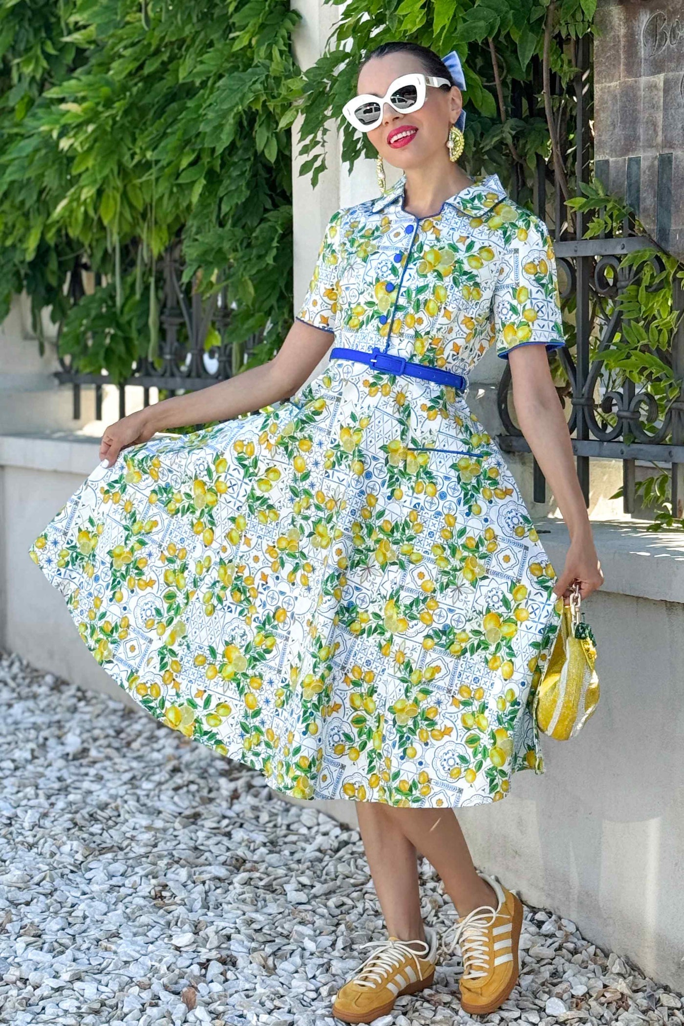 A lady wearing a Mabel Mediterranean Lemon Midi Shirt Dress In White