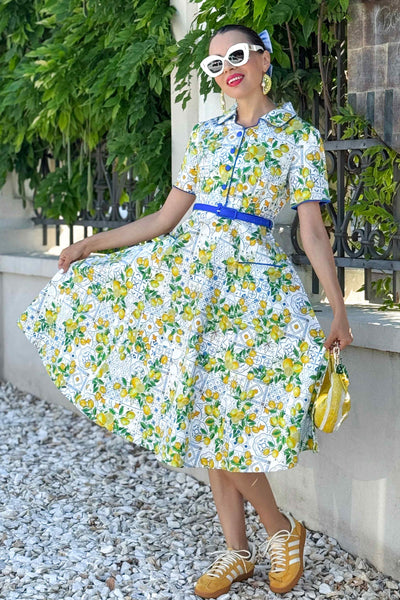A lady wearing a Mabel Mediterranean Lemon Midi Shirt Dress In White