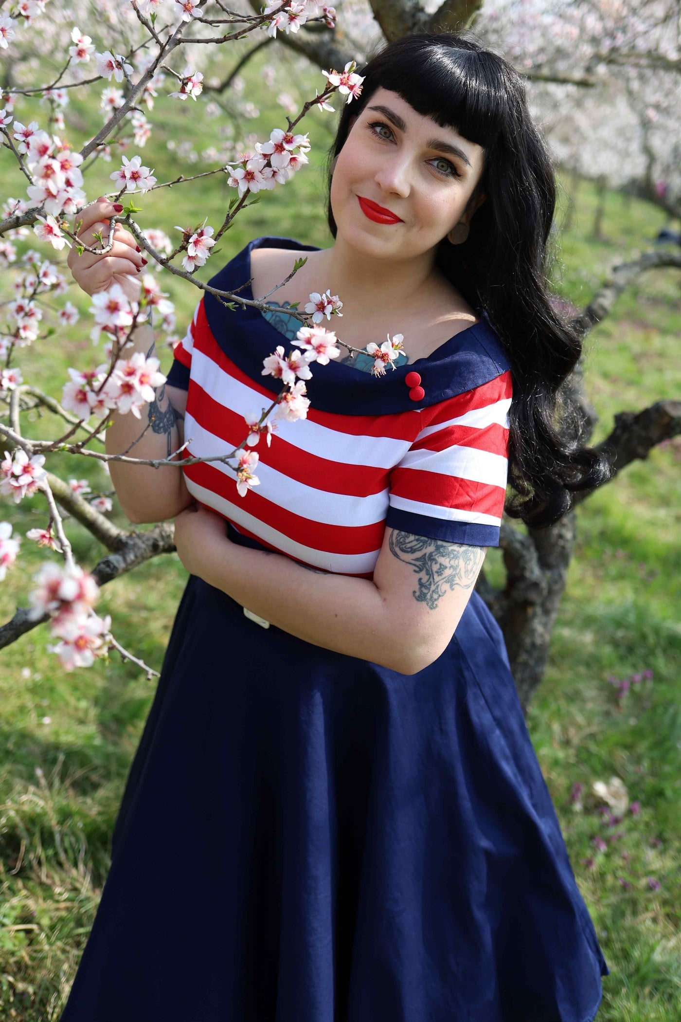 A model wearing a Nautical Swing Dress in Navy with Red & White Stripes