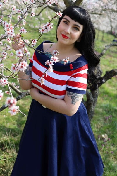 A model wearing a Nautical Swing Dress in Navy with Red & White Stripes