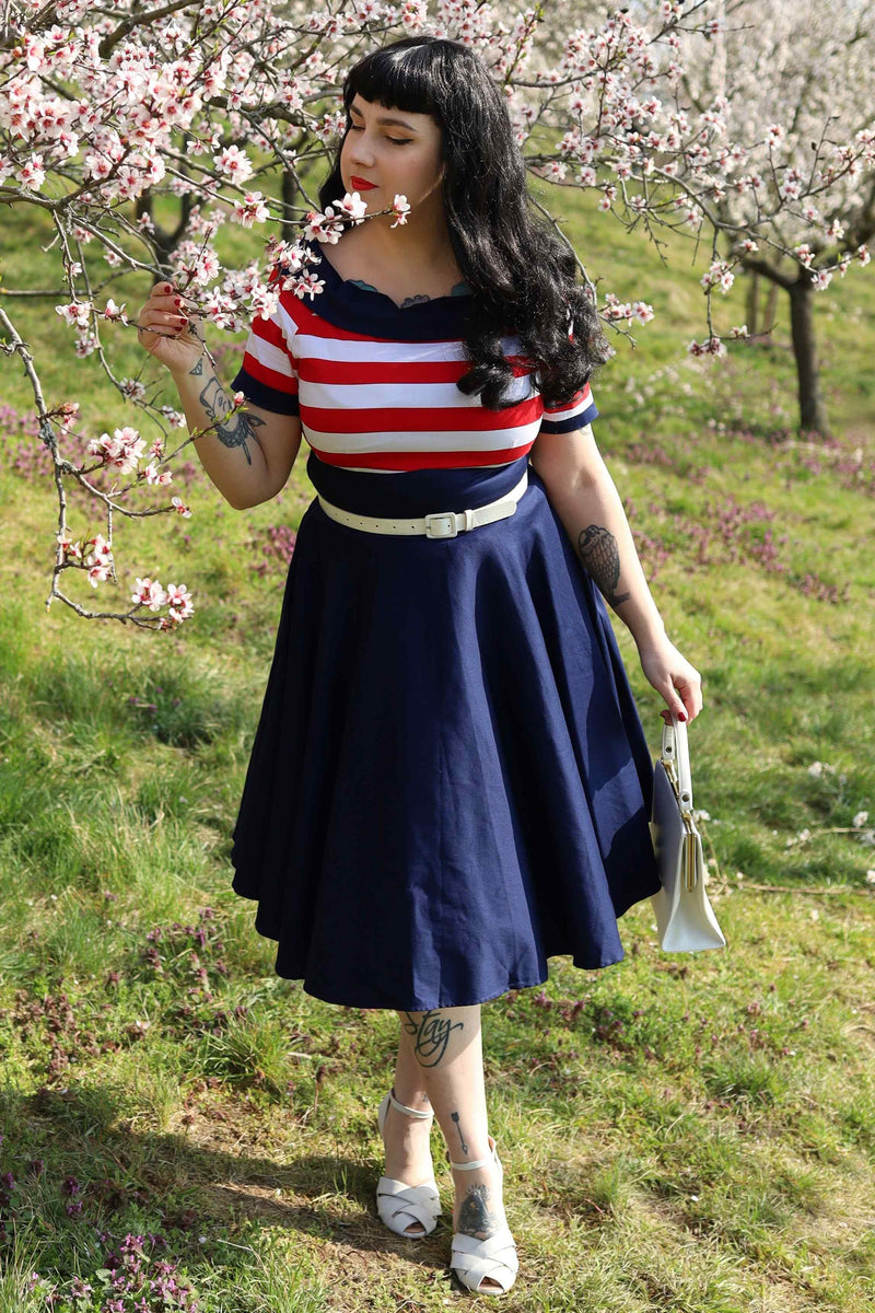 A model wearing a Nautical Swing Dress in Navy with Red & White Stripes