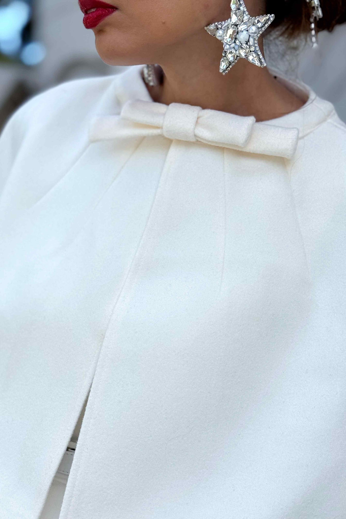 A lovely model wearing a Susan One Shoulder White Swing Dress with Sabrina Ivory White Cape Jacket