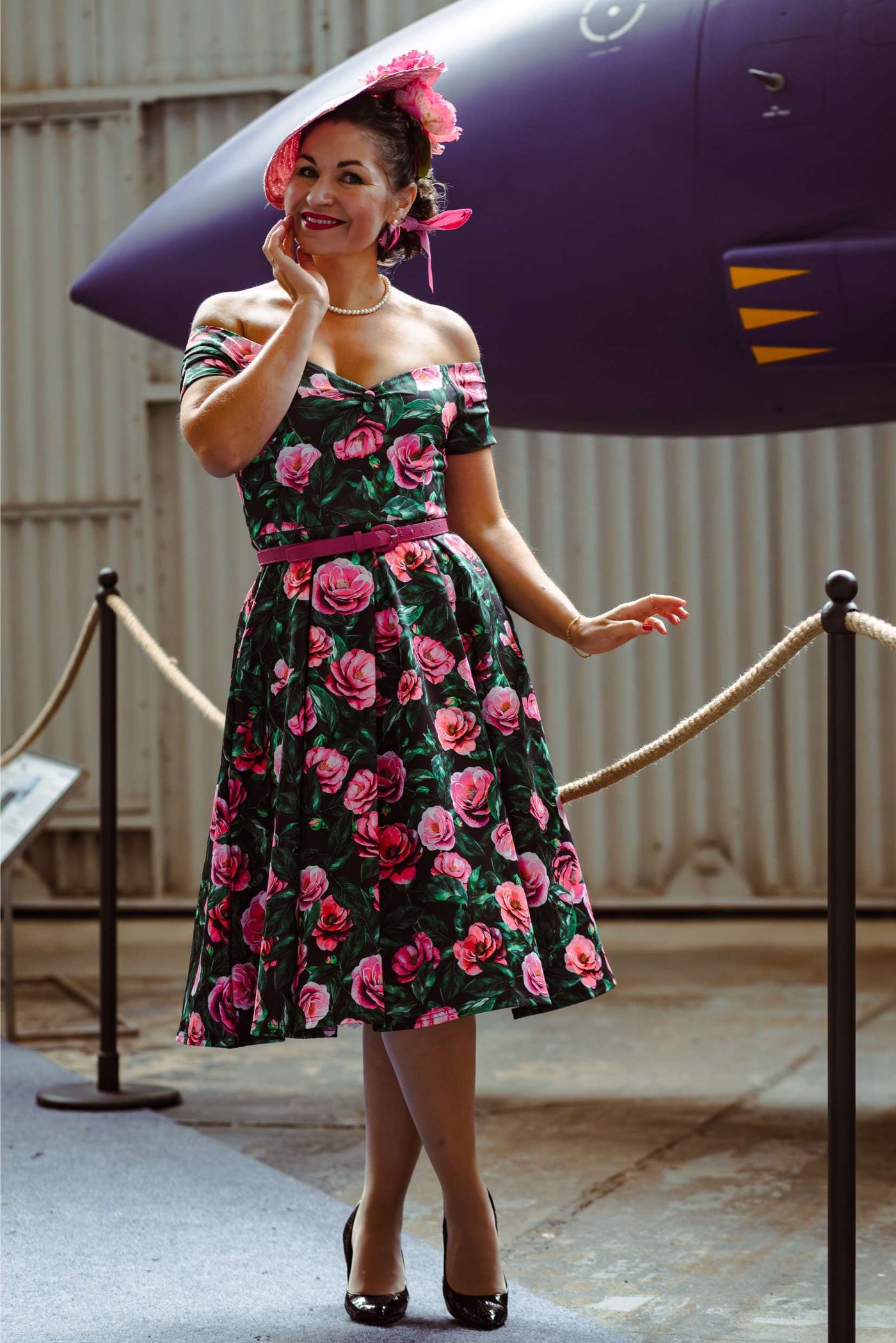 A lady wearing a Lily Pink Camellia Off Shoulder Dress In Black