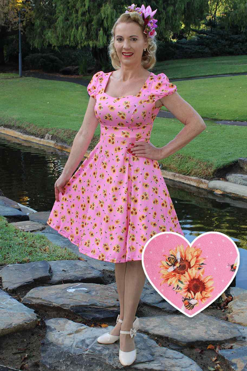A model wearing Pink Cap Sleeved Dress with Sunflowers & Bees