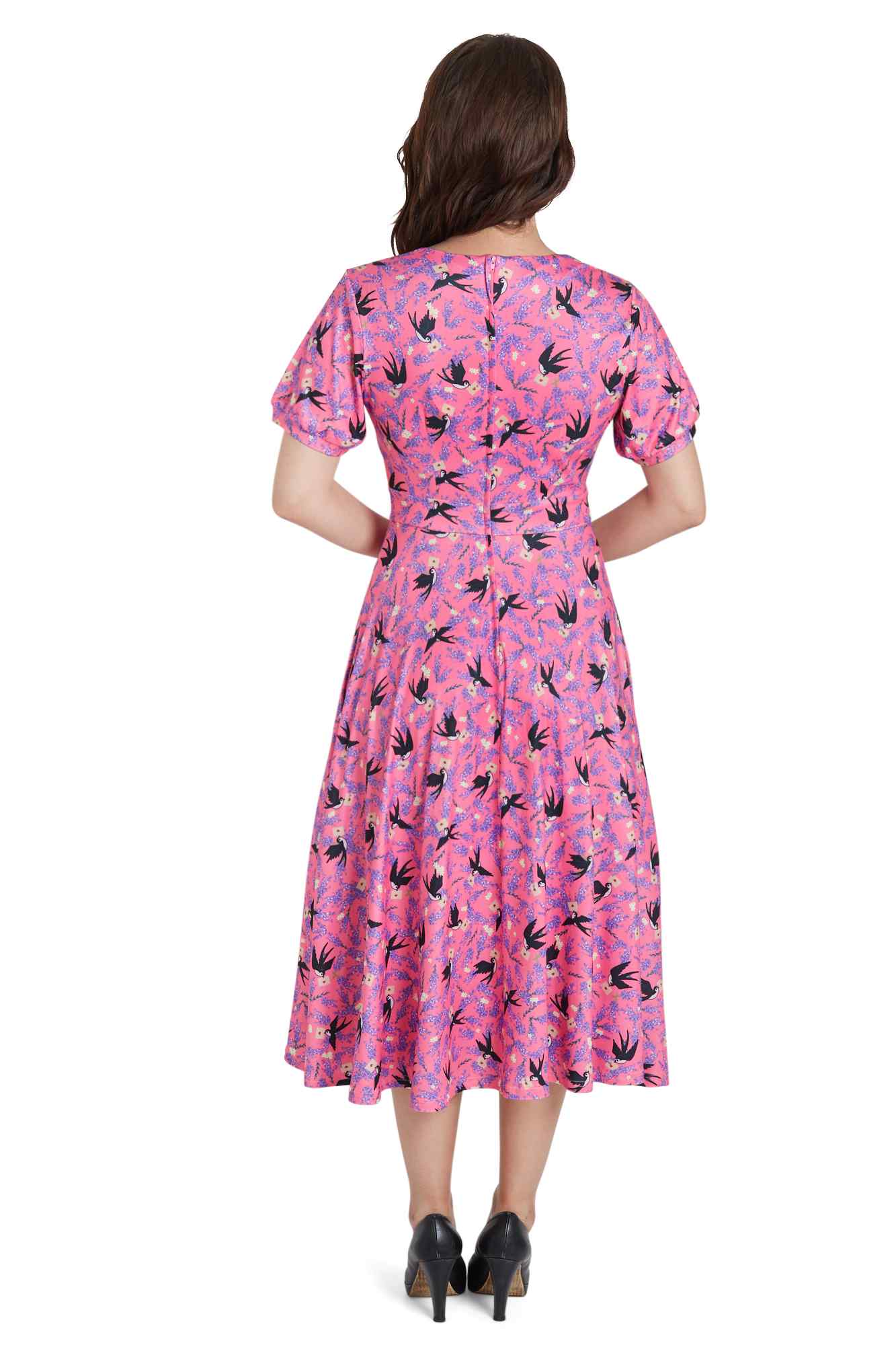 Model wears our pink short sleeved tea dress, with swallow bird print, back view