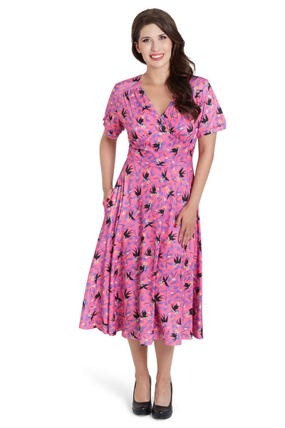 Model wears our pink short sleeved tea dress, with swallow bird print, front view