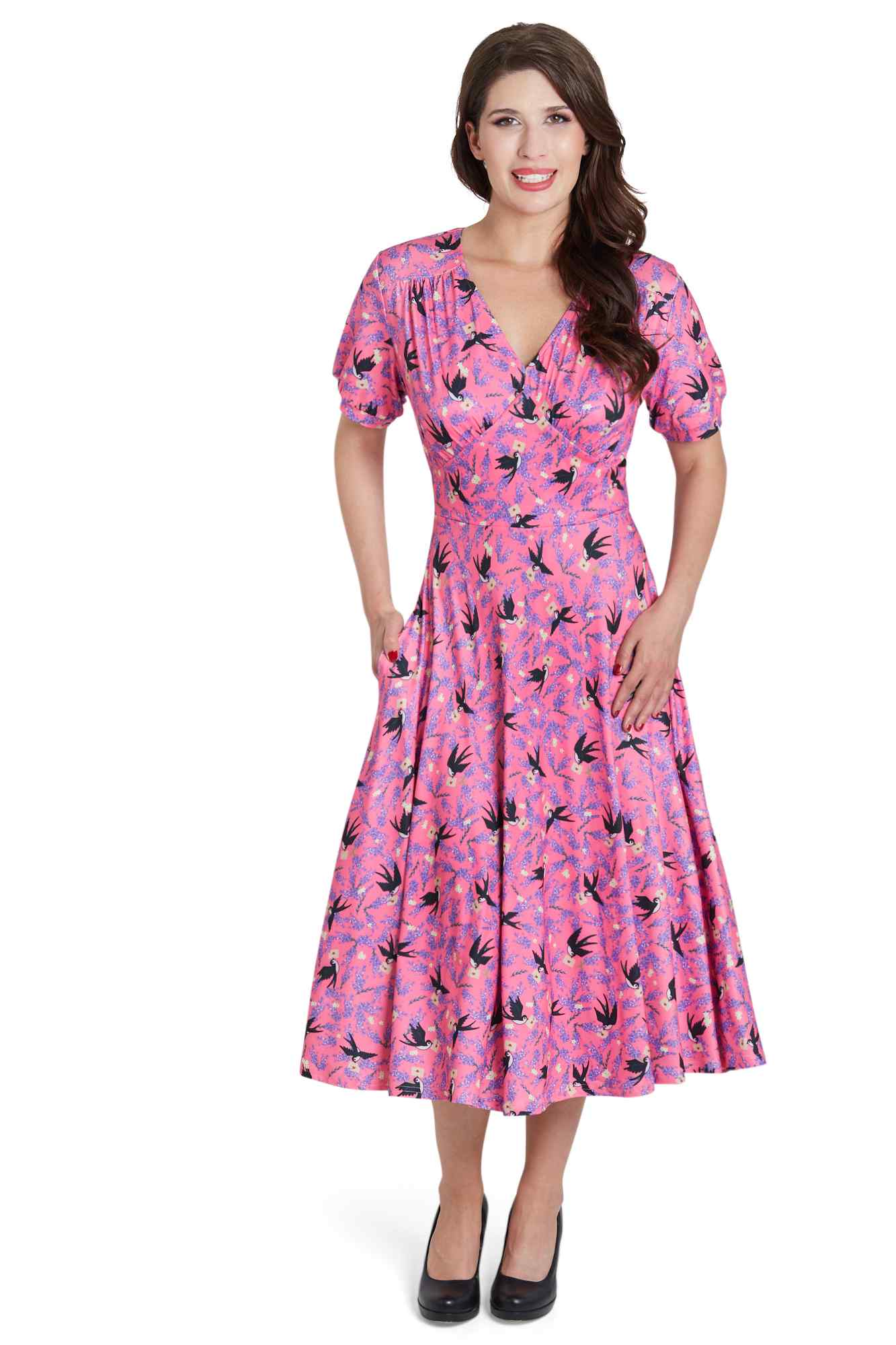 Model wears our pink short sleeved tea dress, with swallow bird print, front view