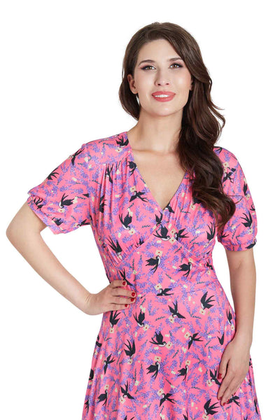 Model wears our pink short sleeved tea dress, with swallow bird print, close view