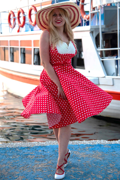 A model wearing a Pleated 50s Style Swing Dress Red Polka Dots