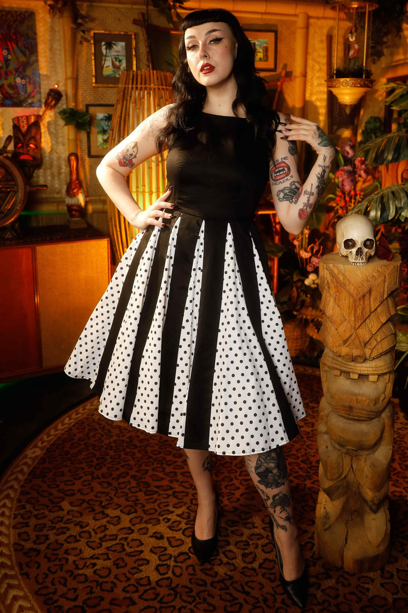 A lady wearing a Pleated Black Dress With White Polka Dots
