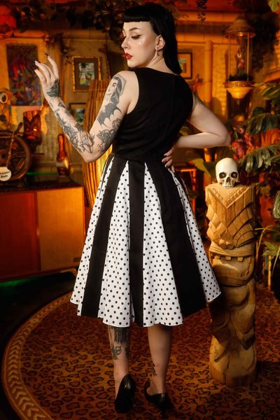 A lady wearing a Pleated Black Dress With White Polka Dots