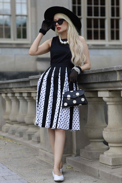 A lady wearing a Pleated Black Dress With White Polka Dots
