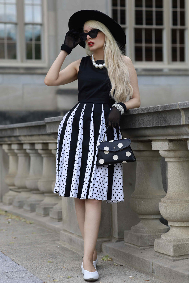 A lady wearing a Pleated Black Dress With White Polka Dots