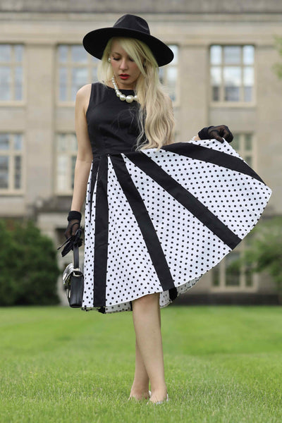 A lady wearing a Pleated Black Dress With White Polka Dots